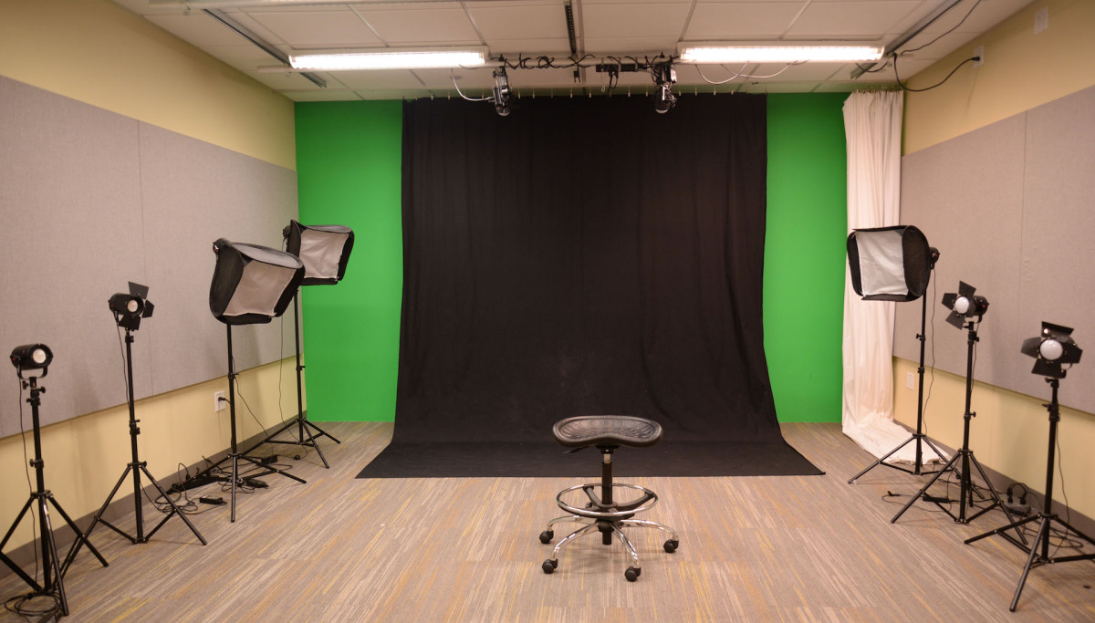 DMC Video and Photography Studio DMC video studio has 2 ceiling mounted lights, 7 lights on the floor and a black curtain and a white curtain.