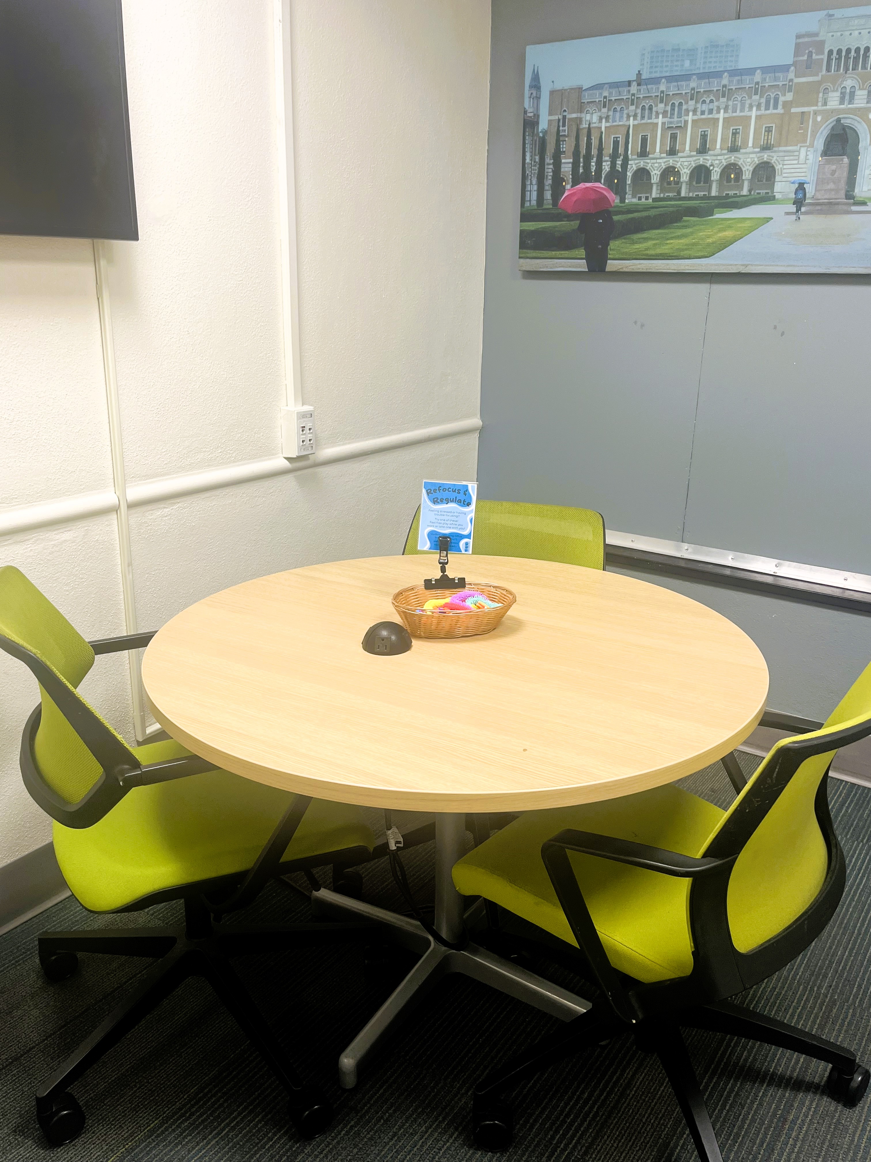 interior of study room with green chairs and basket of fidget toys on table