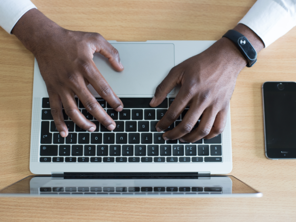 Overhead photo of hands using a laptop